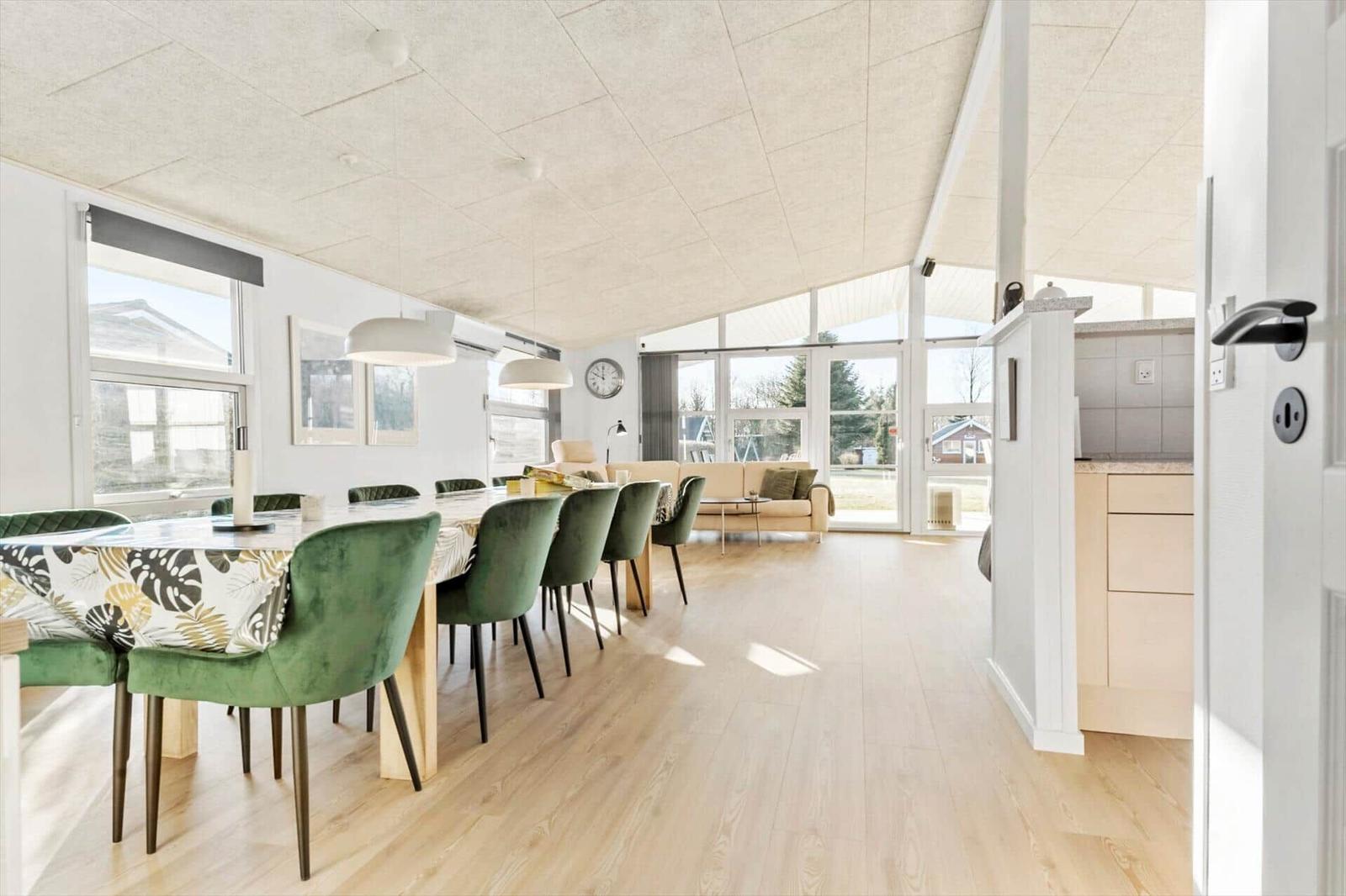 Dining room with green chairs and view into the living room.