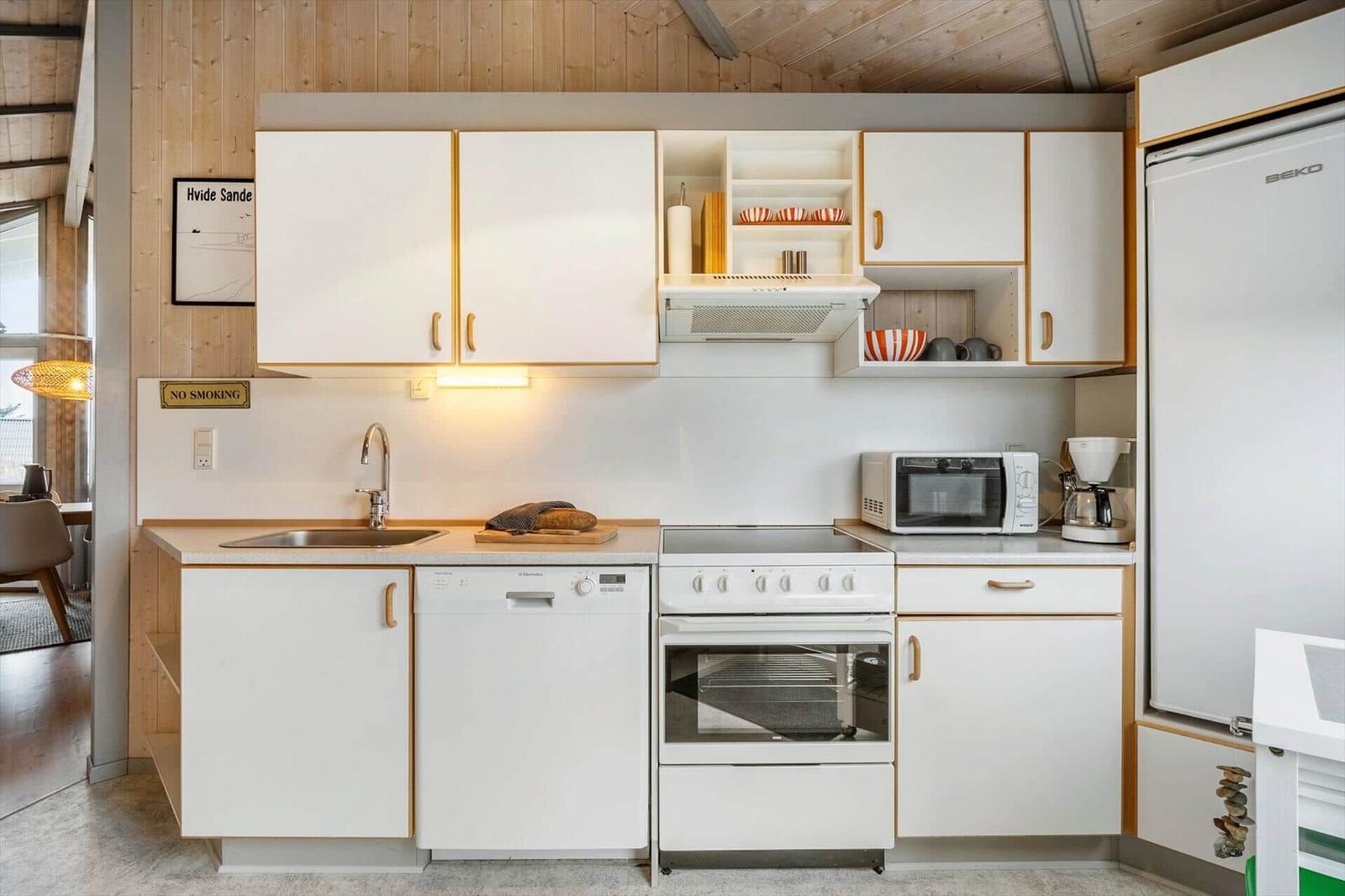 Kitchen with white cabinets, sink, stove, and refrigerator.