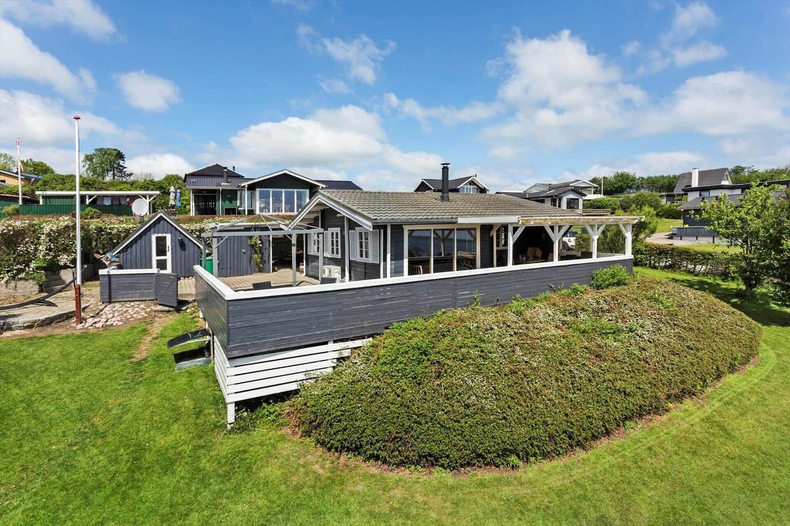 A house with terrace and garden under a blue sky.