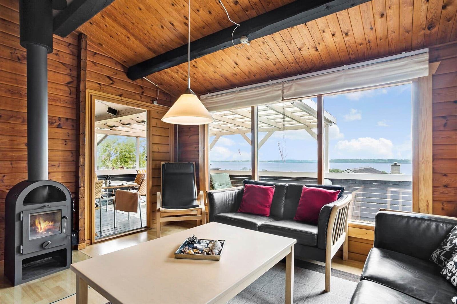 Living room with wooden walls, fireplace, and water view