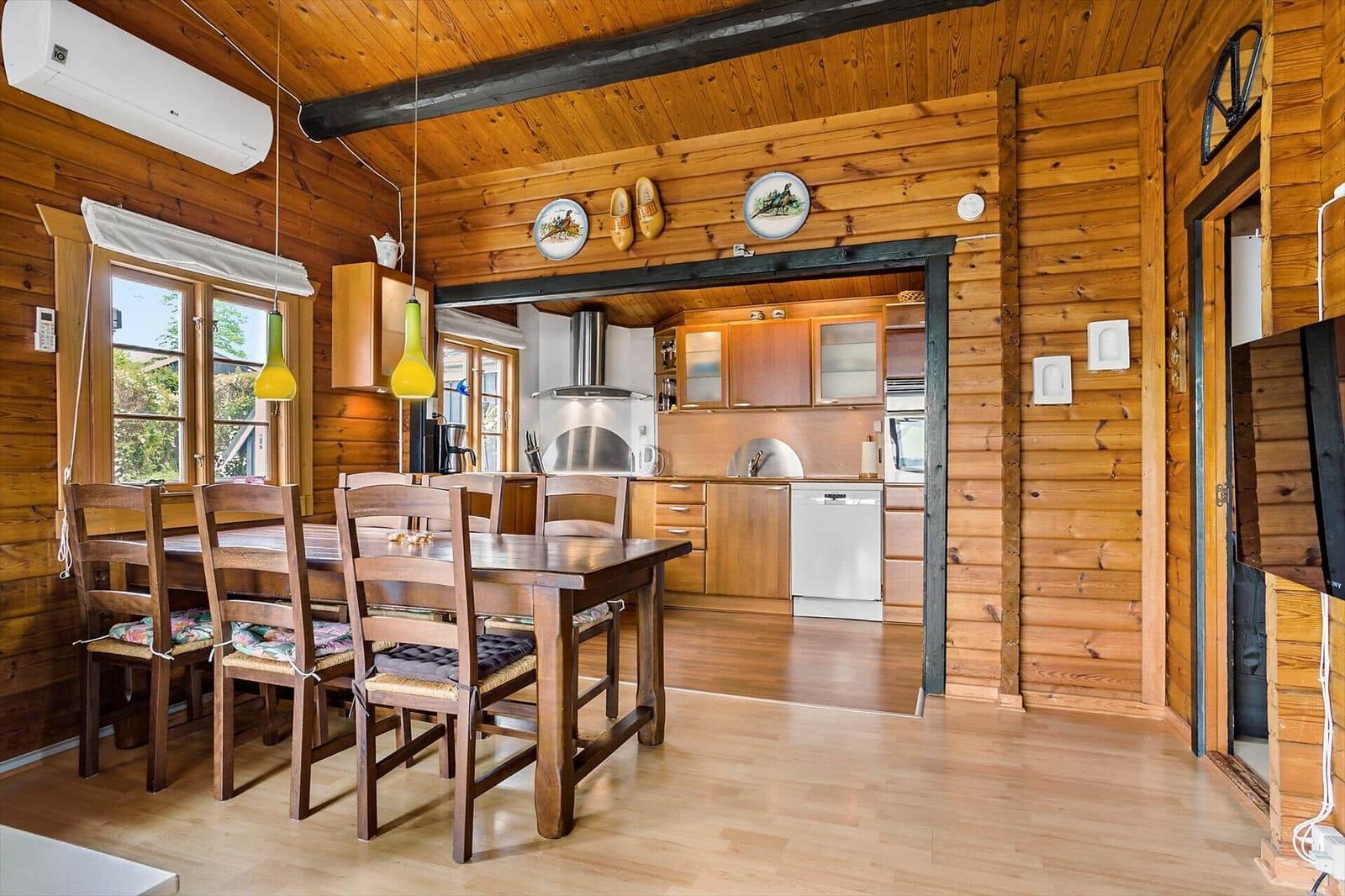 Dining area with wooden table and chairs. Kitchen with wooden cabinets and stainless steel appliances.