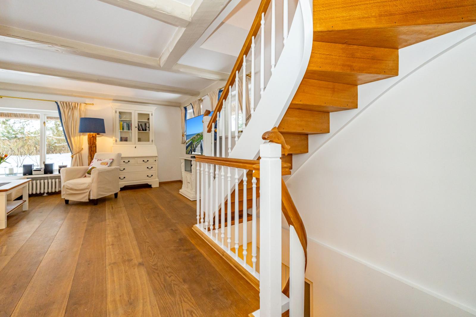 Haus mit Holzstufen und weißer Geländerstruktur im Wohnbereich.