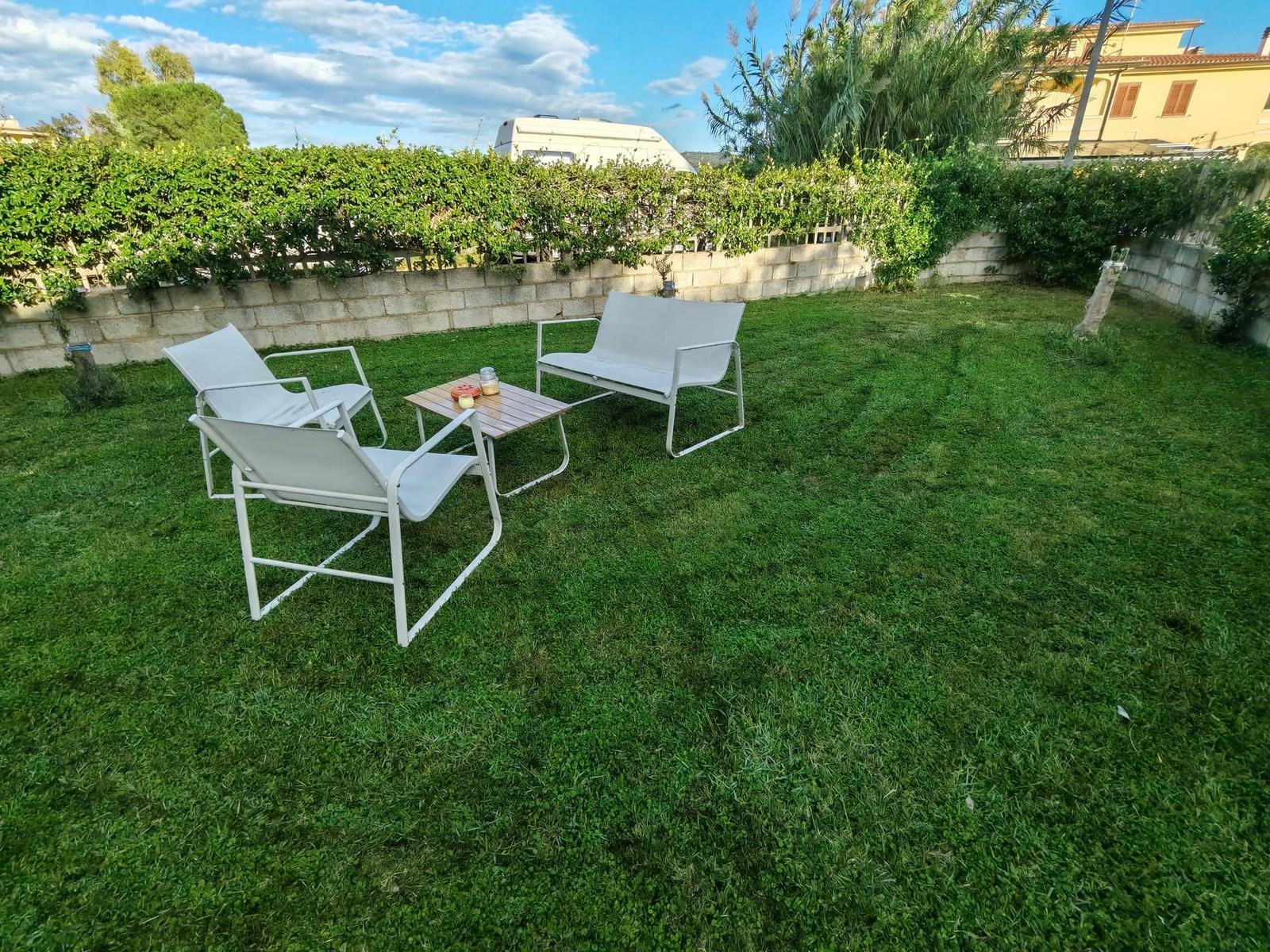 Garden with white seating and green lawn.