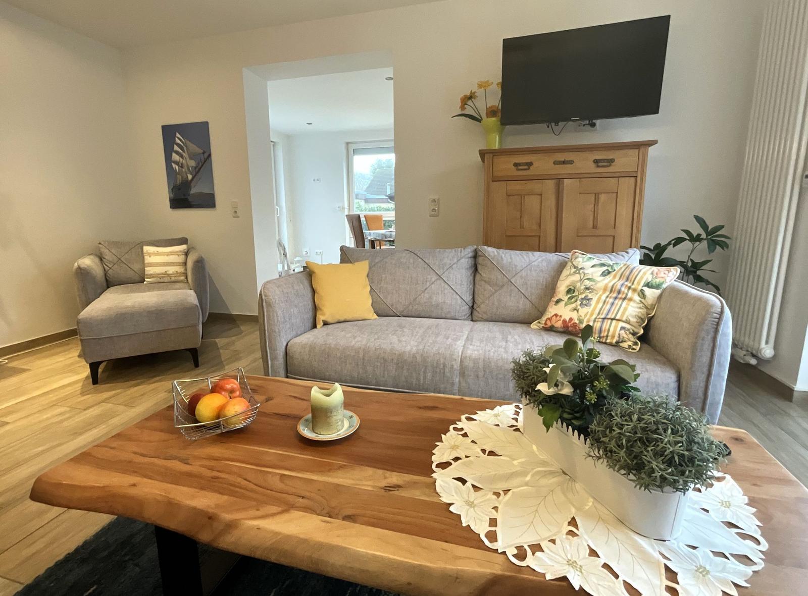 Wohnzimmer mit Sofa, Couchtisch und Fernseher.