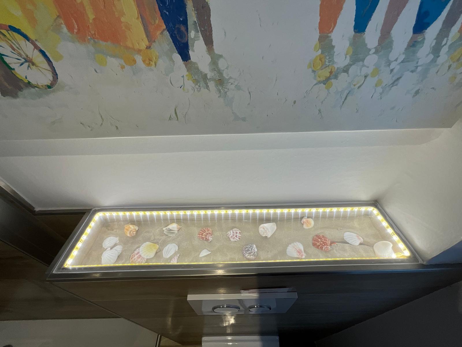 Schale-Dekoration mit LED-Beleuchtung unter Wandbild