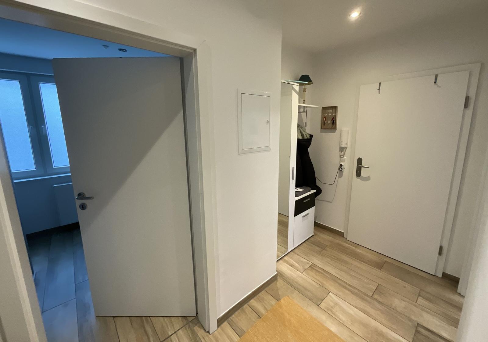 Eingangsbereich mit Holzboden und Tür zu Wohnbereich