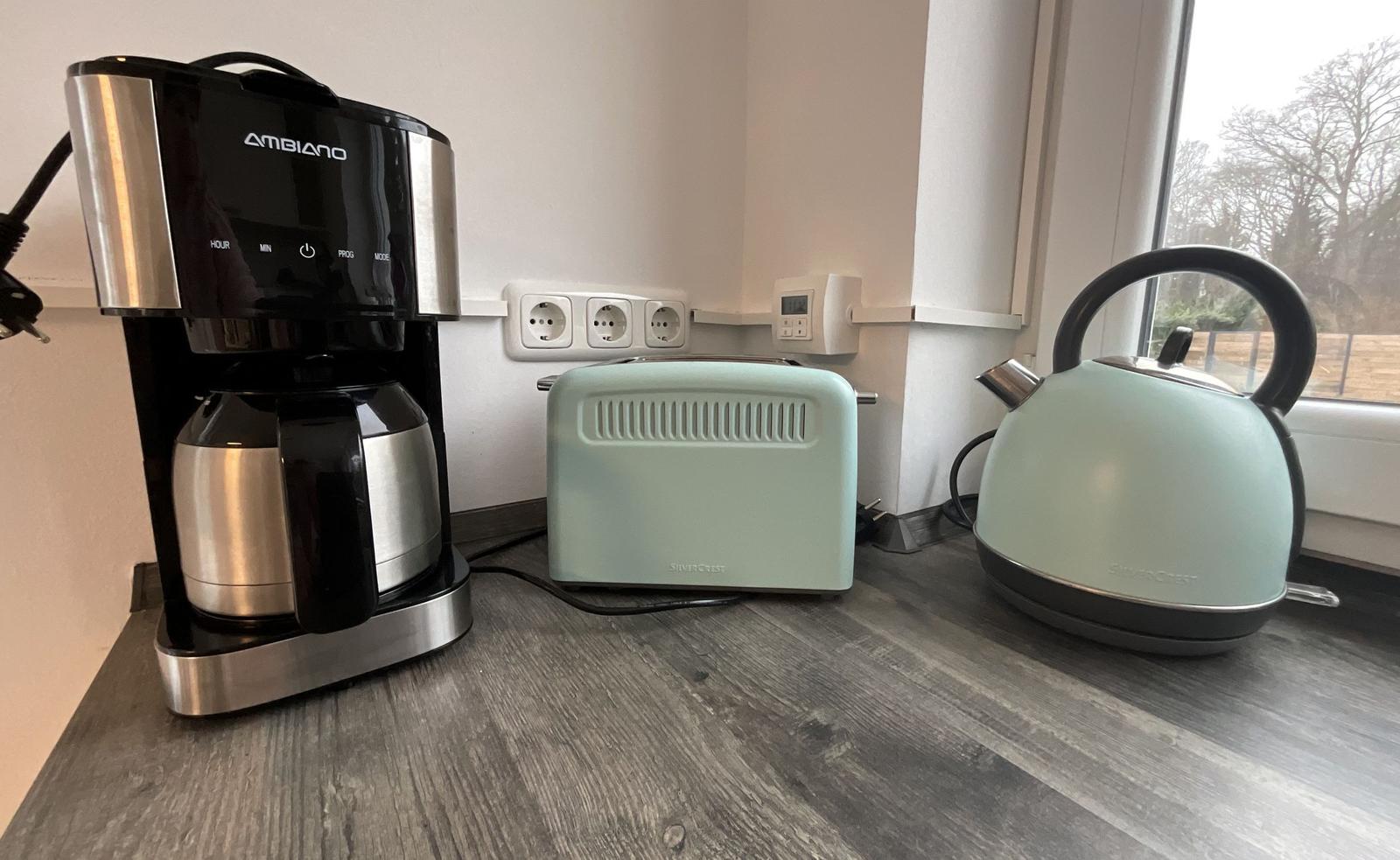 Küchenzeile mit Kaffeemaschine, Toaster und Wasserkocher.