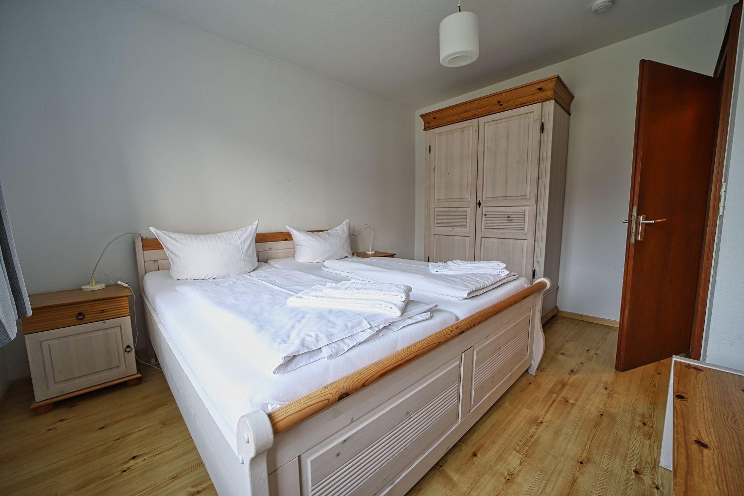 Schlafzimmer mit Doppelbett, Kleiderschrank und Nachttisch.