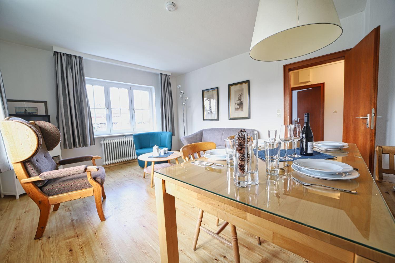 Esszimmer mit Tisch und Stühlen. Wohnbereich mit Sofa und Sessel.