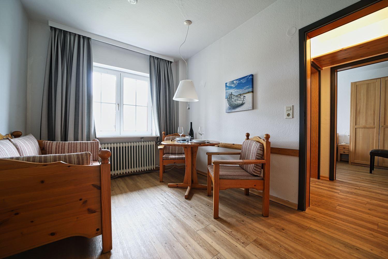 Wohn- und Essbereich mit Holzmöbeln und Blick aus dem Fenster.