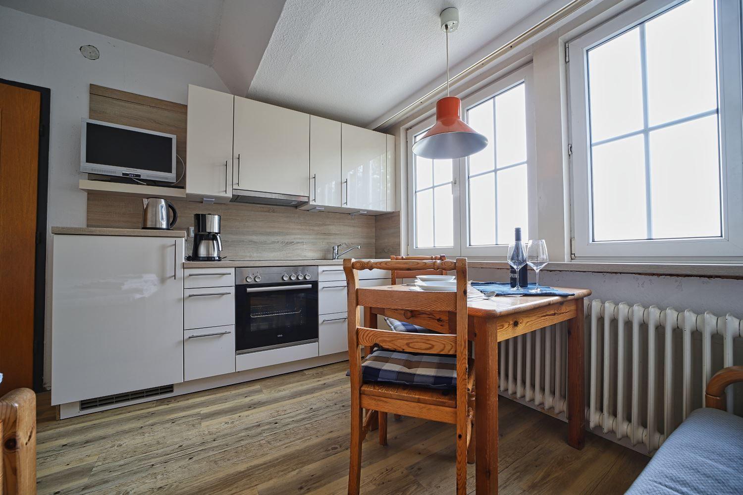 Küche mit Essbereich, Holztisch, Stühle und Fenster