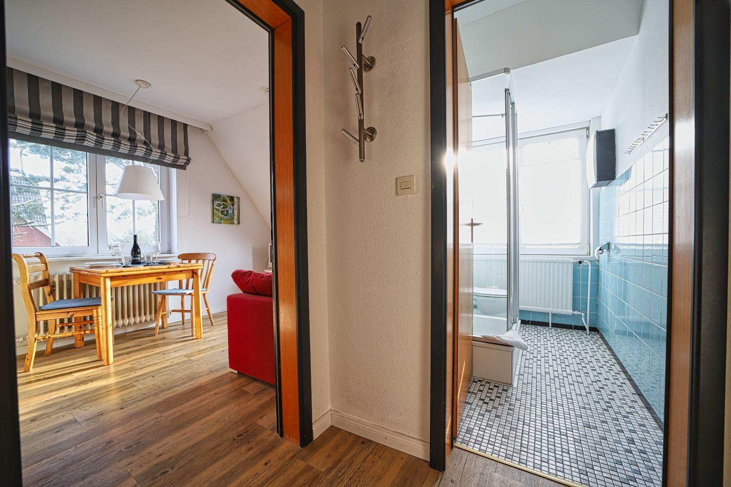 Durchgang zu Esszimmer und Bad mit Dusche und Badewanne.