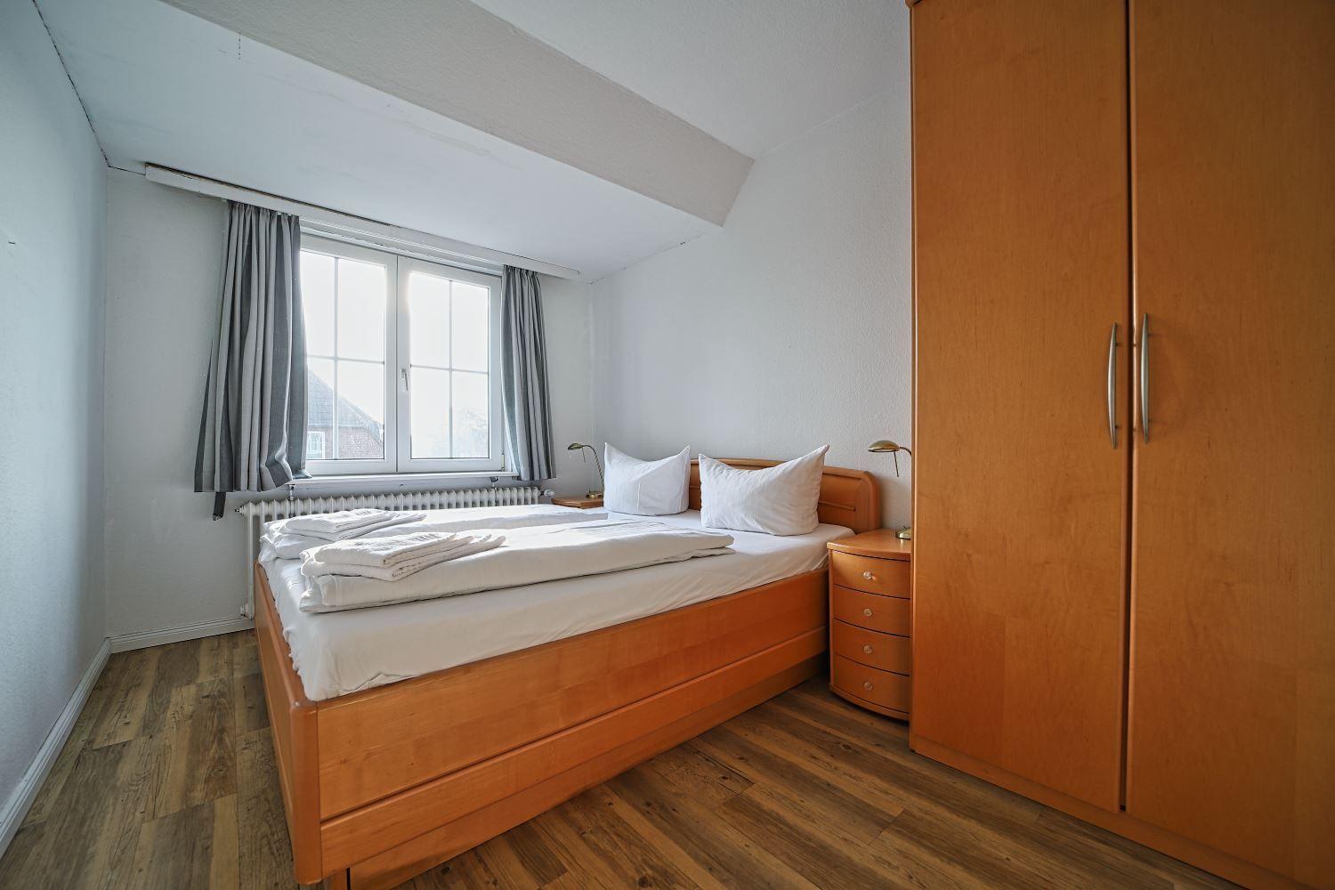 Schlafzimmer mit Doppelbett, Kleiderschrank und Fenster mit Blick.