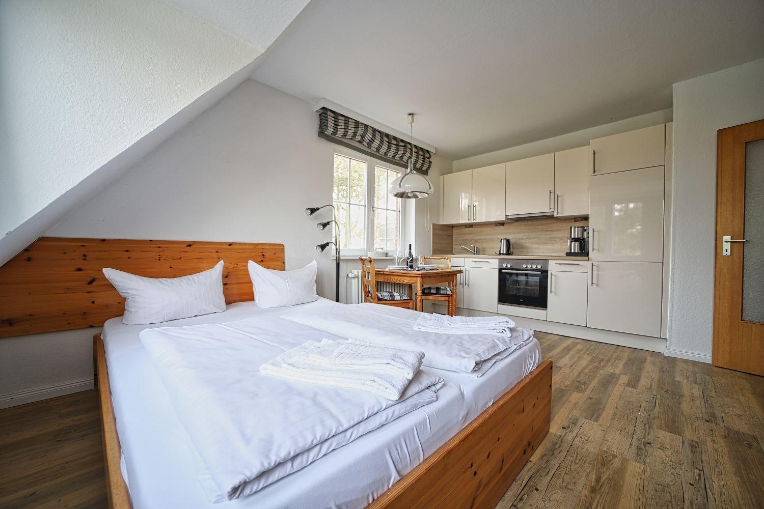 Schlafzimmer mit Doppelbett und integriertem Küchenbereich.