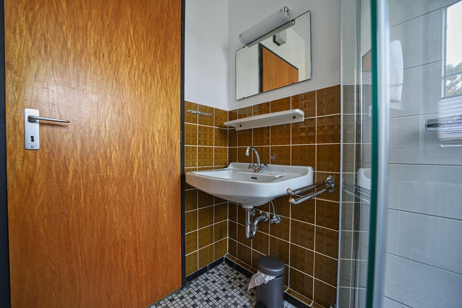 Bad mit Waschbecken, Spiegel und Dusche