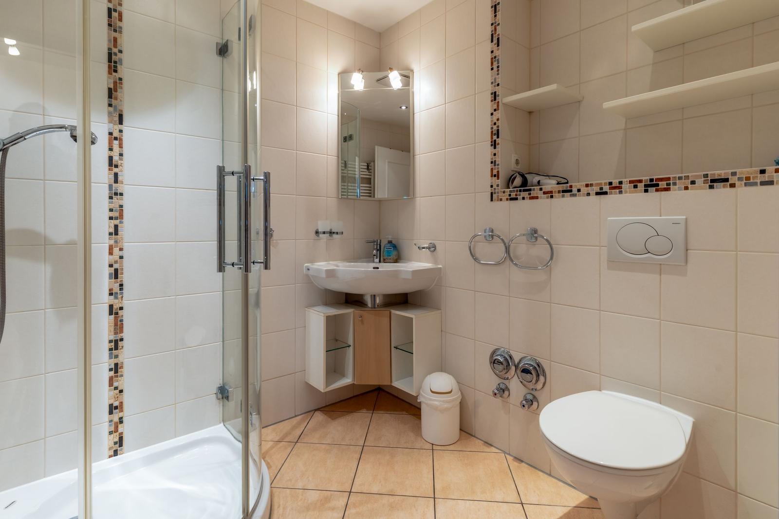 Badezimmer mit Dusche, Waschbecken und Toilette