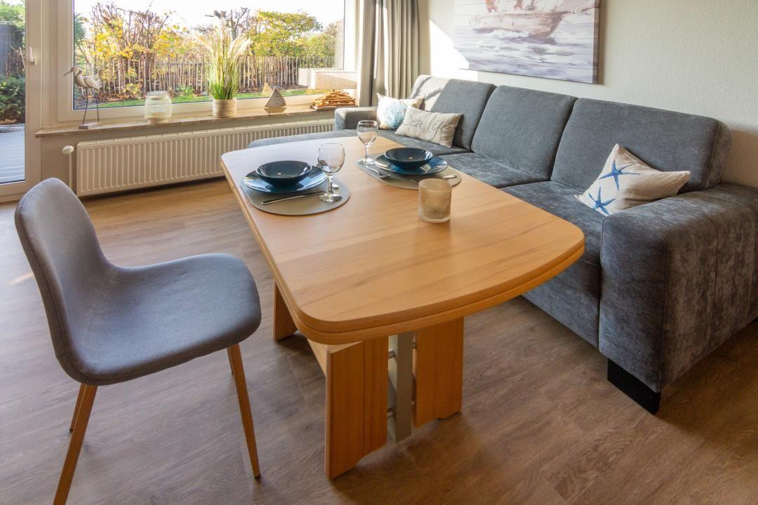 Essbereich mit Tisch, Stuhl und Sofa. Fenster mit Blick auf Garten.