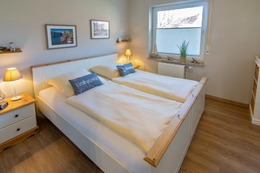 Schlafzimmer mit Doppelbett, Nachttisch und Fenster