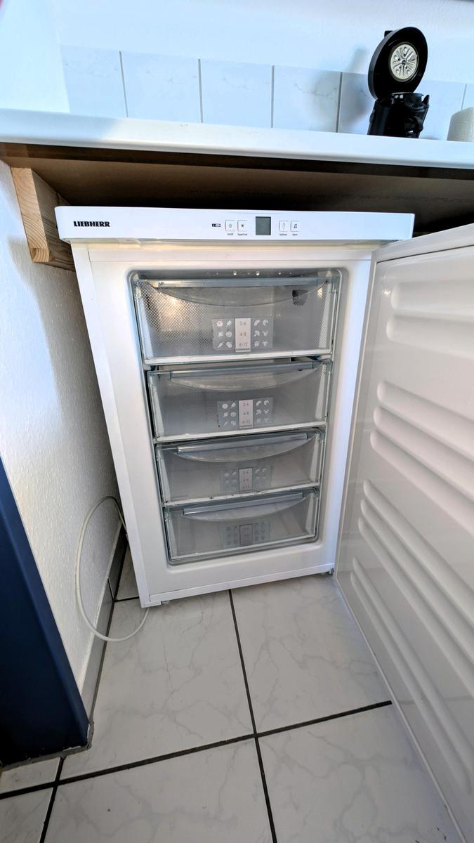 Weißer Kühlschrank mit vier Schubladen und digitaler Anzeige.