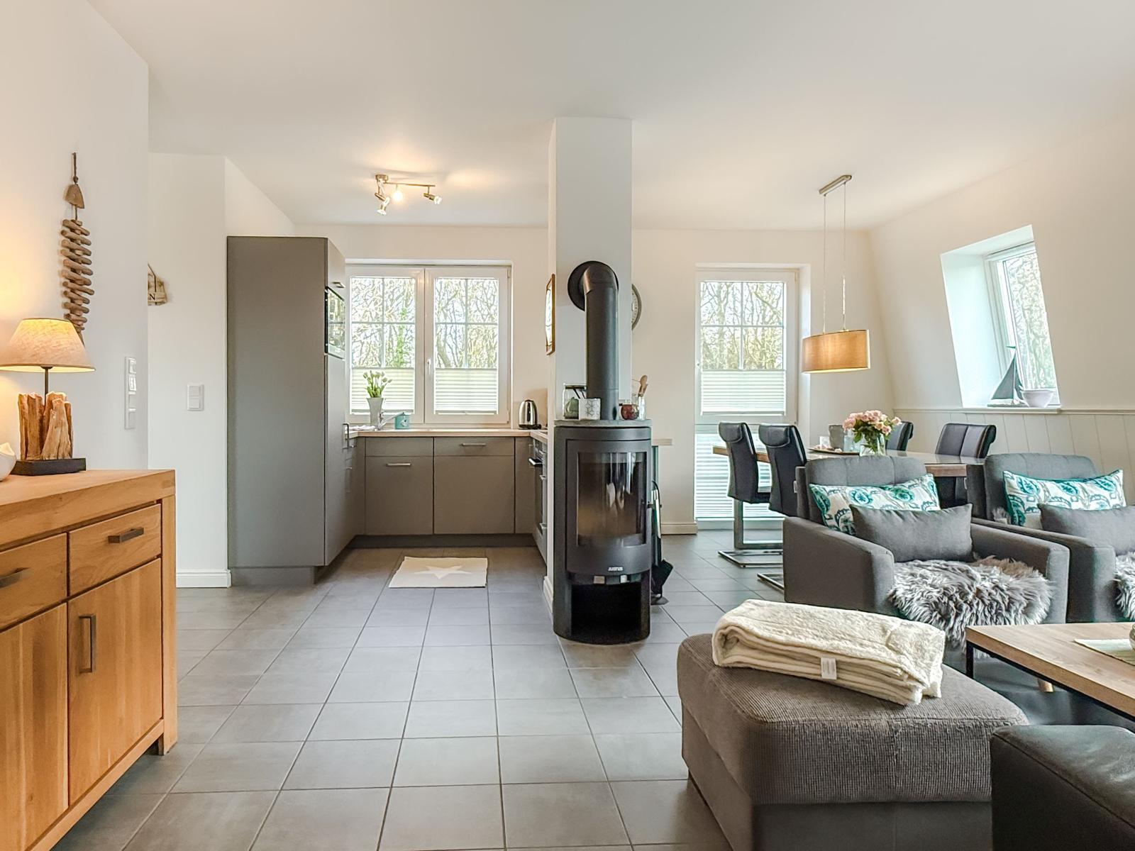 Wohn- und Essbereich mit Kaminofen und Küchenbereich.