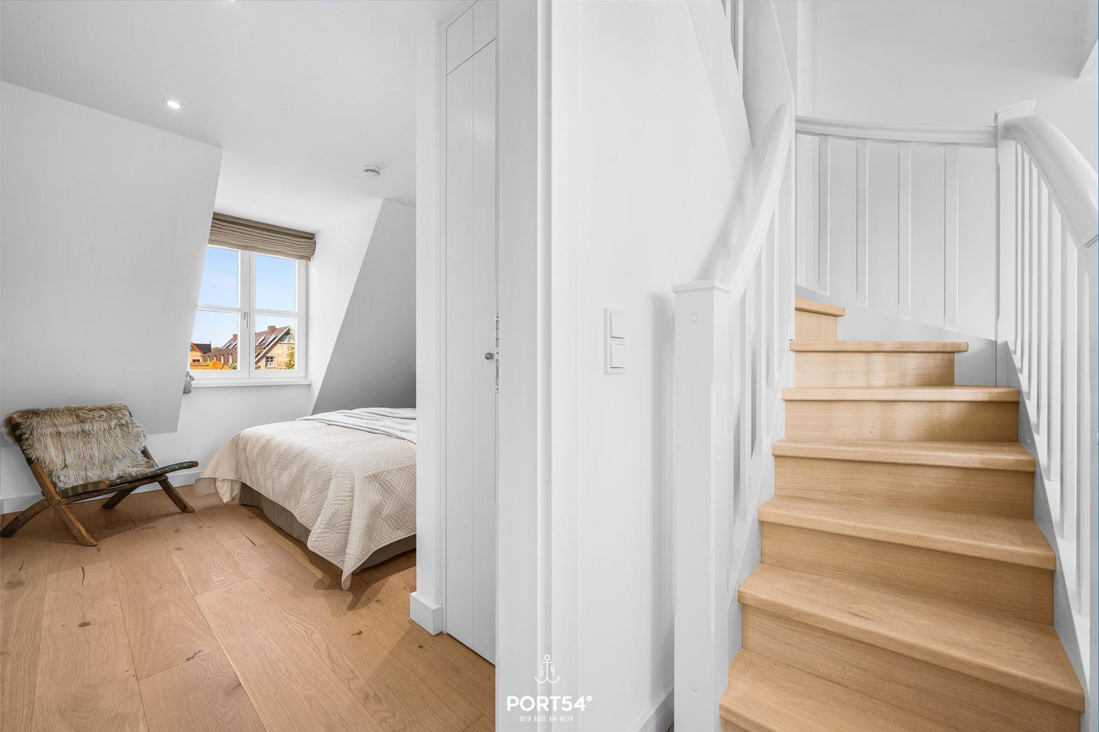 Schlafzimmer mit Dachfenster und Holztreppe