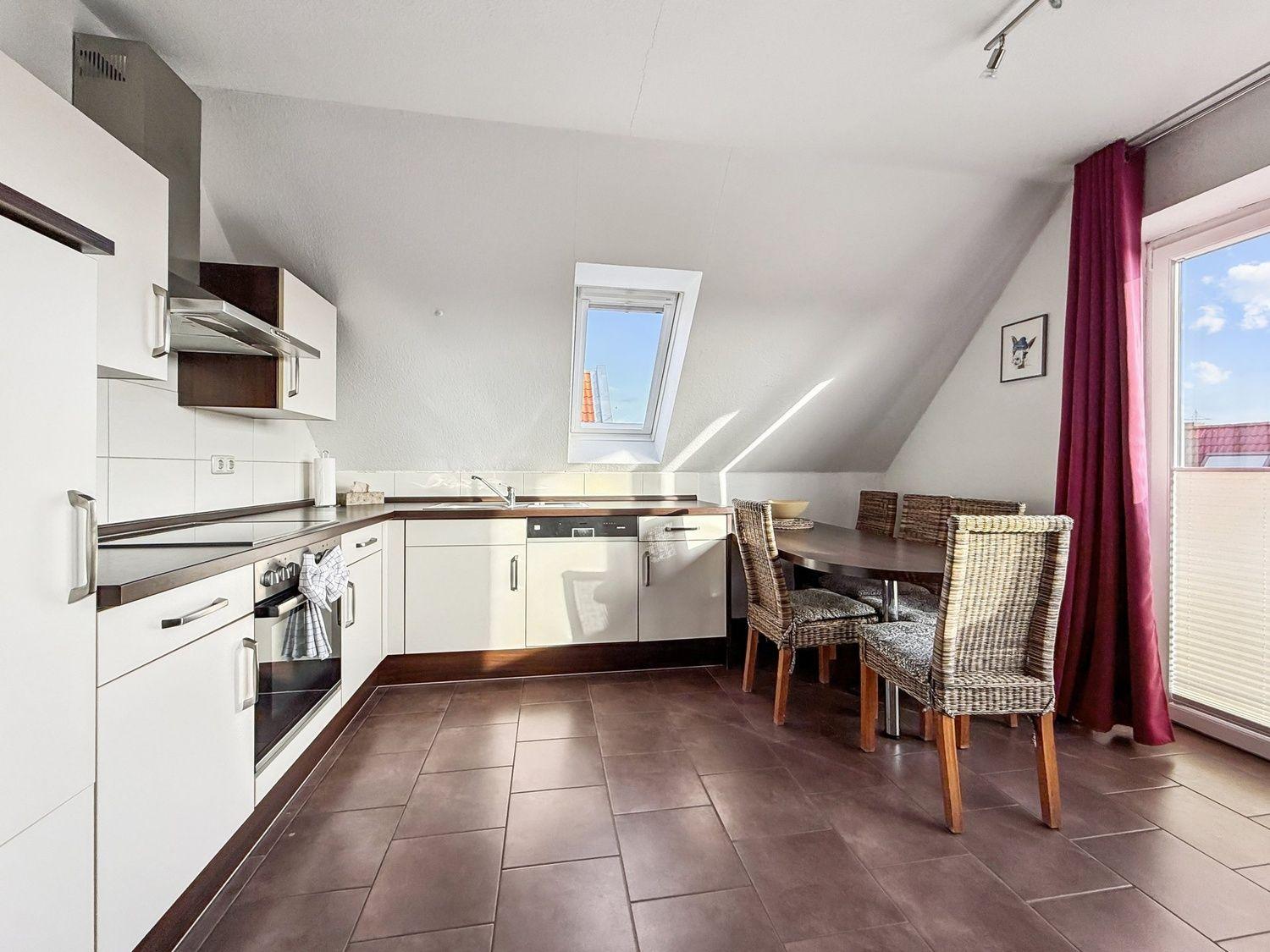 Küche mit Essbereich, Dachfenster und Terrassentür.