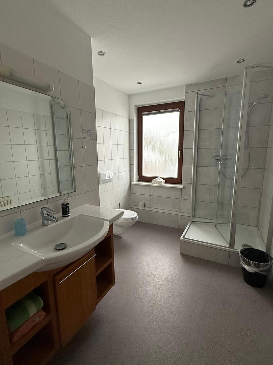 Badezimmer mit Dusche, Waschbecken und Toilette