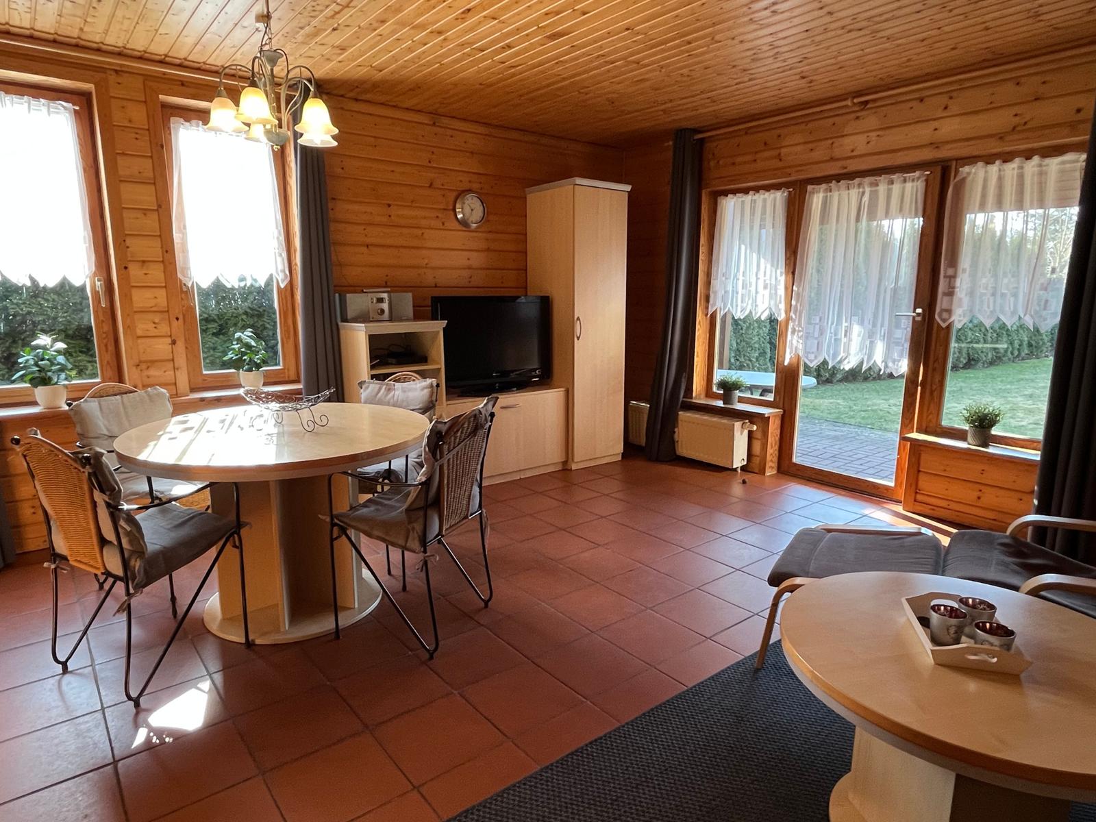 Wohn- und Essbereich mit Holzwand, Terrasse und Esstisch