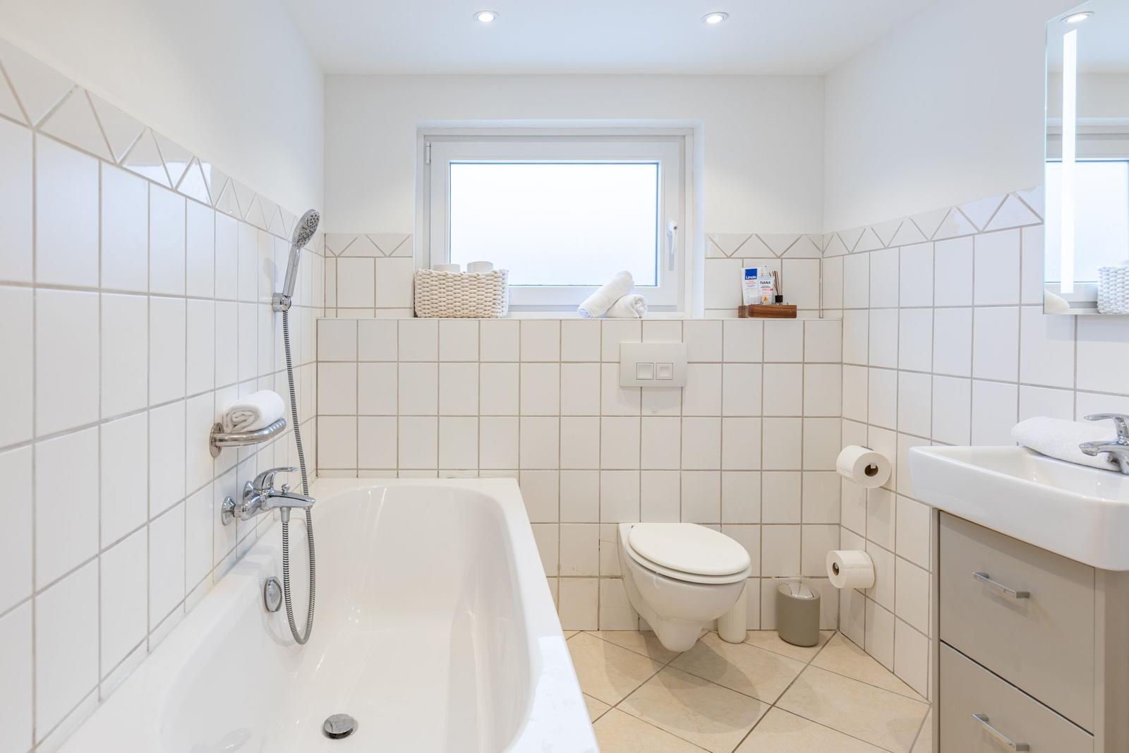 Badezimmer mit Badewanne, Toilette und Waschbecken.