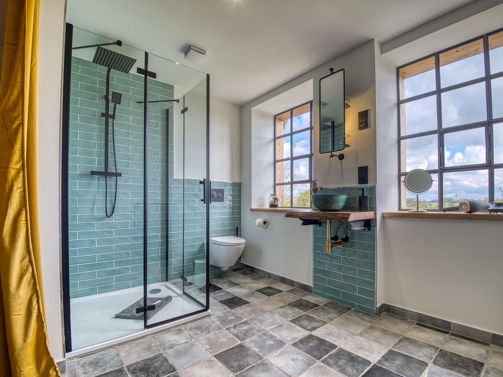 Badezimmer mit Dusche, Toilette und Waschtisch mit Fenster