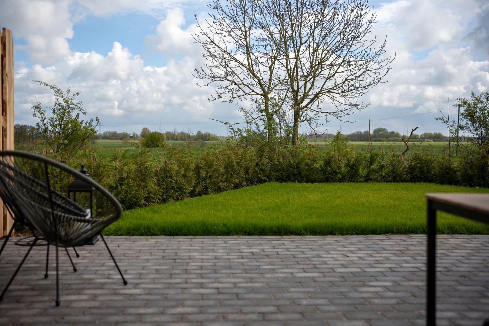 Terrasse mit Gartenblick, Sitzgelegenheit und Rasenfläche