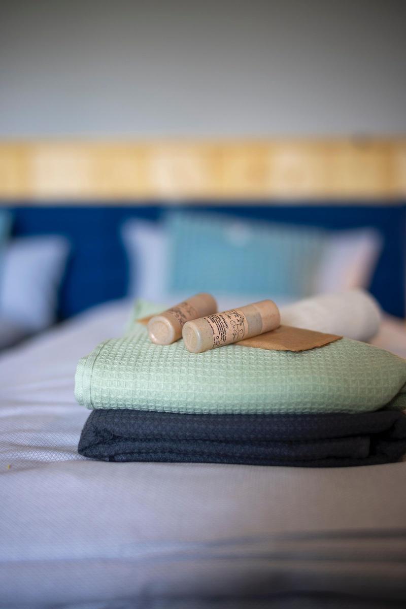 Gefaltetes Handtuch und zwei Holzstifte auf Bett mit Kopfteil.