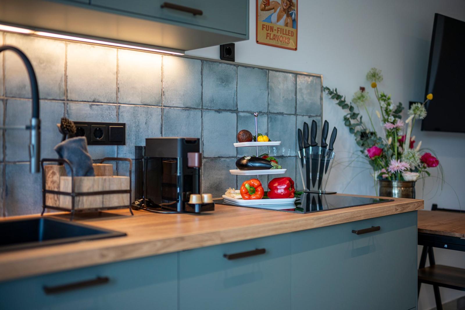 Küche mit Holzoberfläche, Edelstahlspüle und moderner Kochplatte.