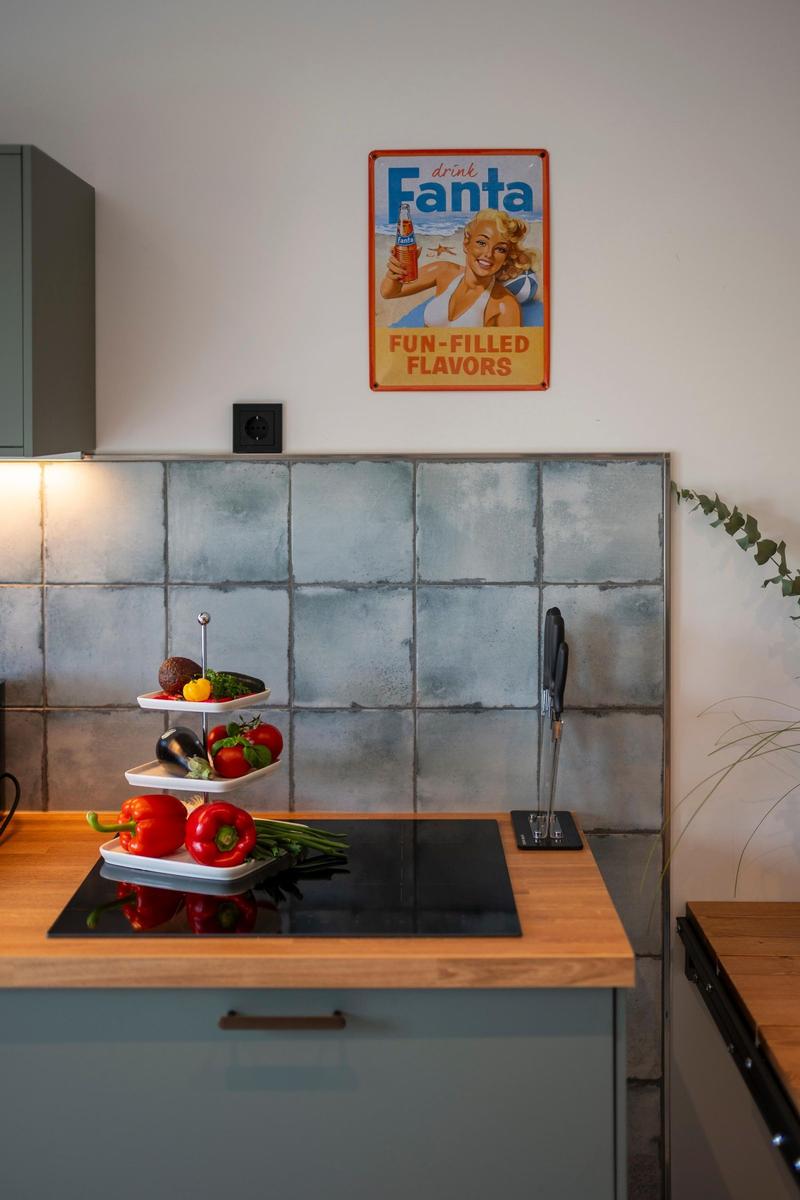 Küche mit Holzoberfläche, Steinwand und Fanta-Wandposter.