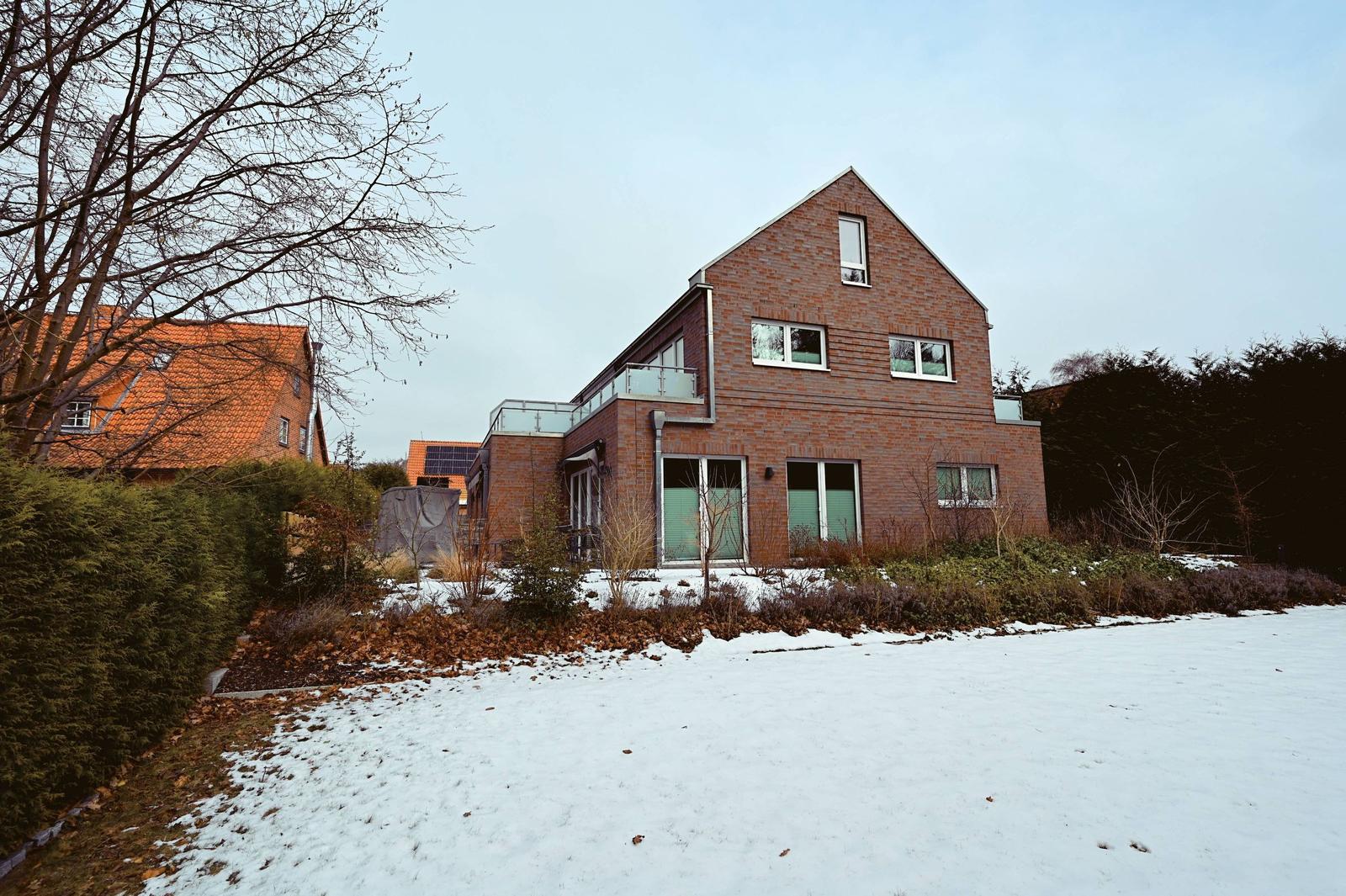 Moderne Villa mit Schneebedecktem Grundstück und Glasbrüstung.