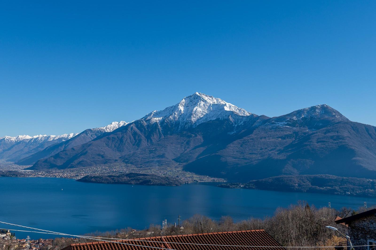 Blick auf schneebedeckte Berge über einen See.