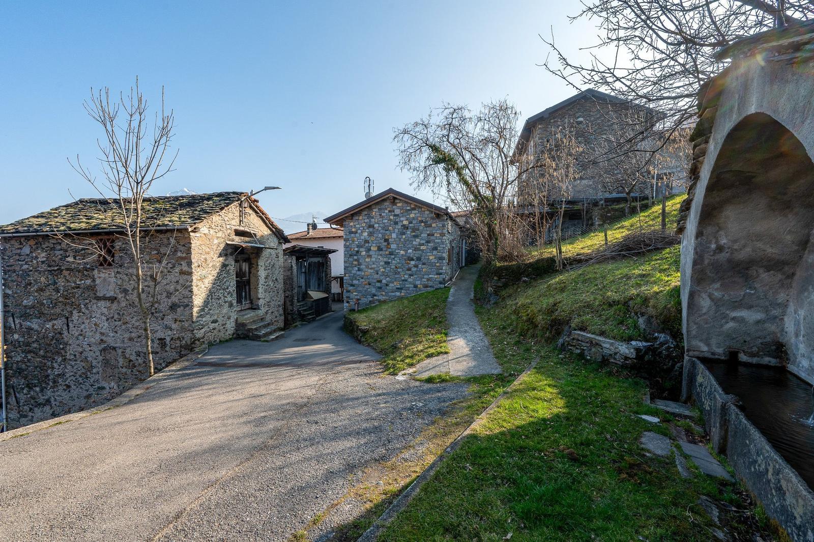 Steinhaus mit Pfad und Brücke in ländlicher Umgebung