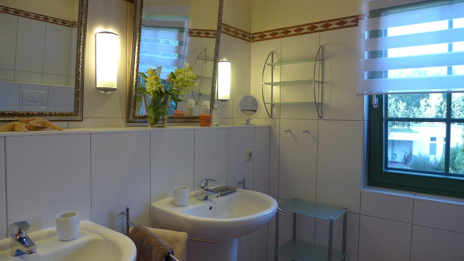 Badezimmer mit zwei Waschbecken, Spiegeln und Fenster.