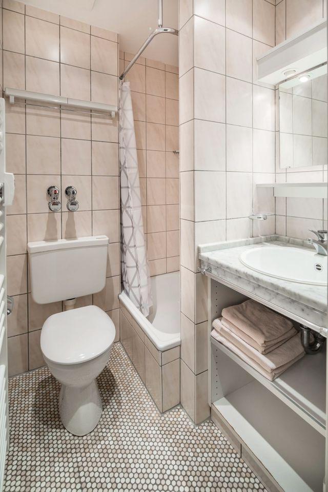 Badezimmer mit Toilette, Dusche und Waschbecken mit Spiegel