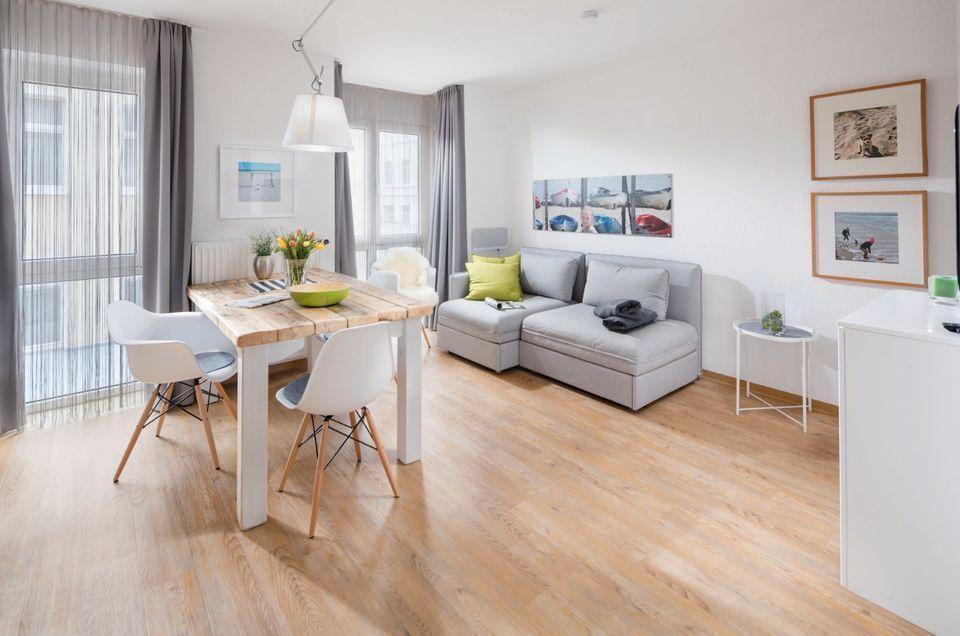 Wohn- und Essbereich mit Sofa, Esstisch und Holzboden.
