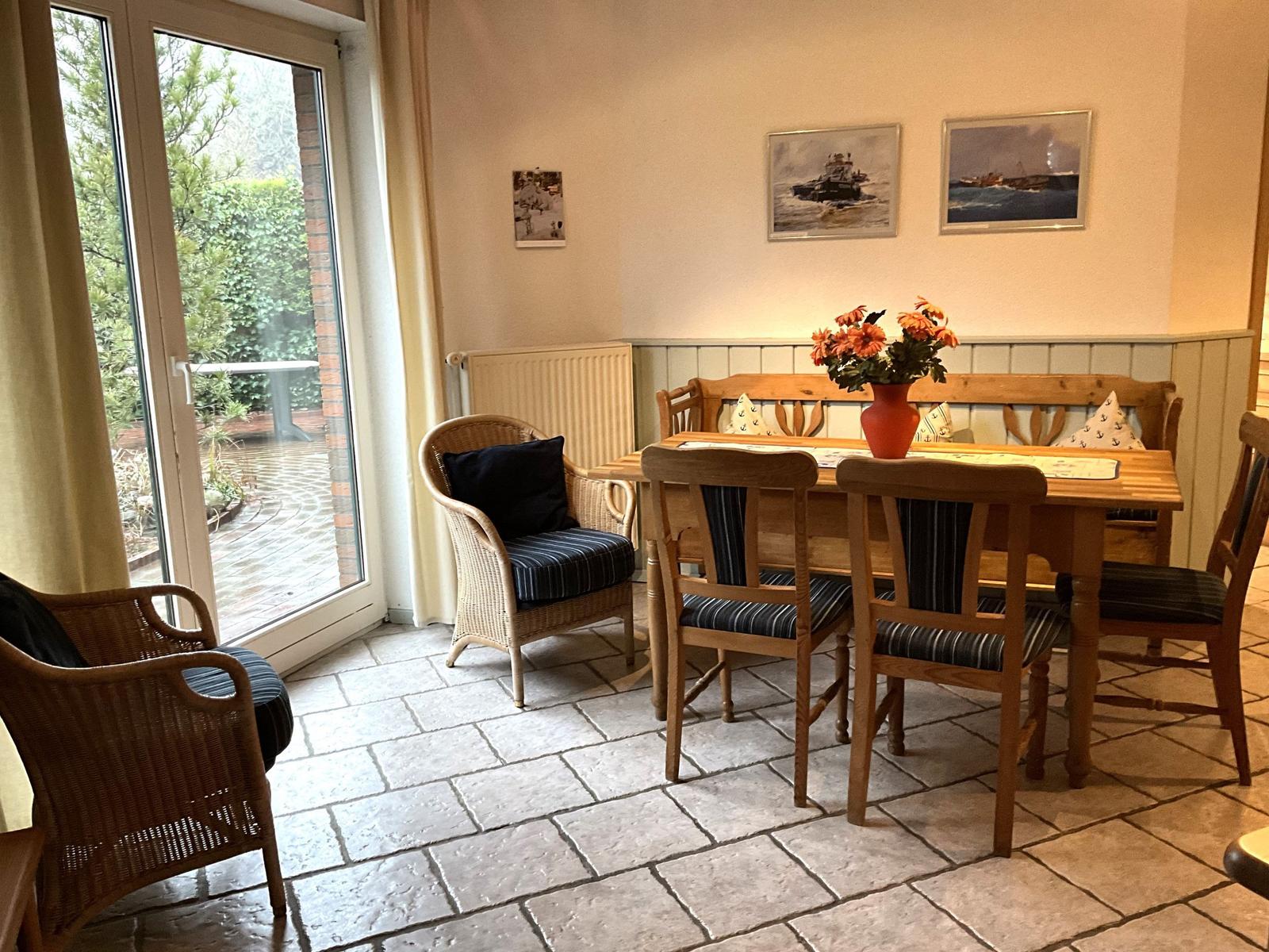 Esszimmer mit Holztisch, Stühlen und Blick auf Balkon