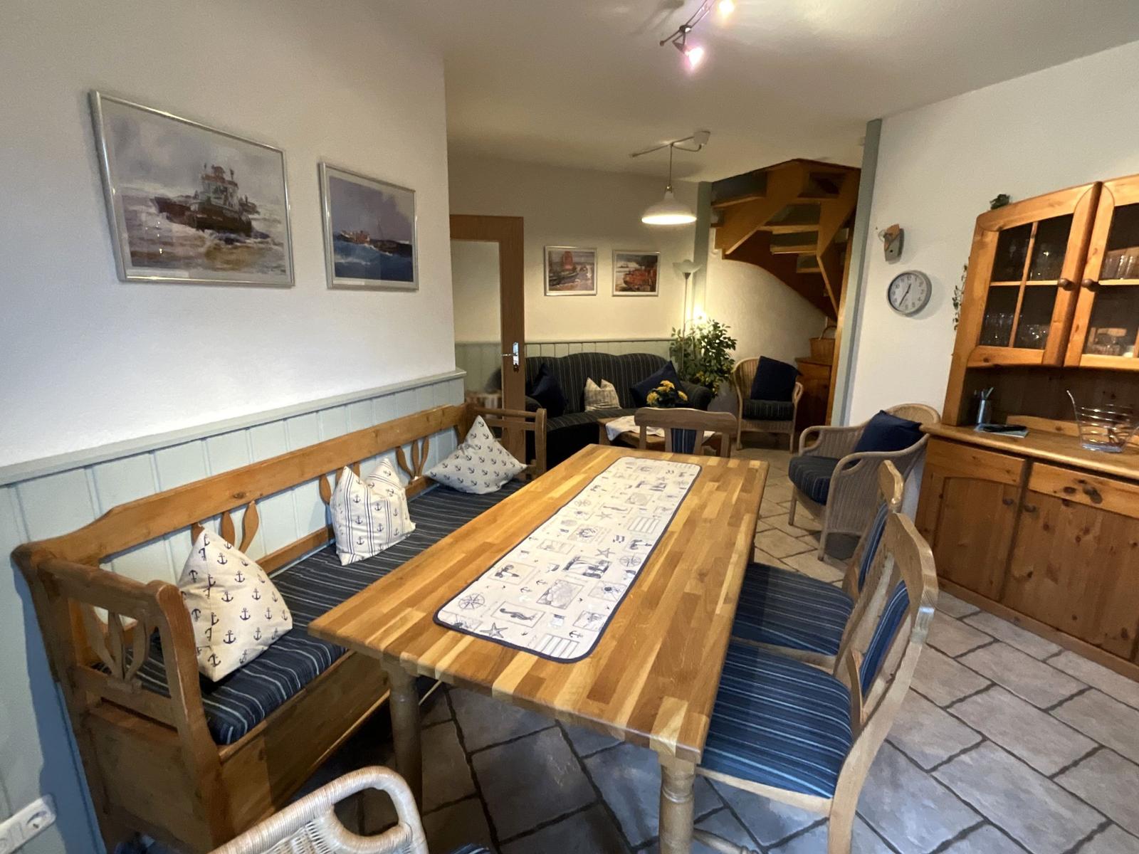 Esszimmer mit Holztisch, Bänken und Küchenzeile