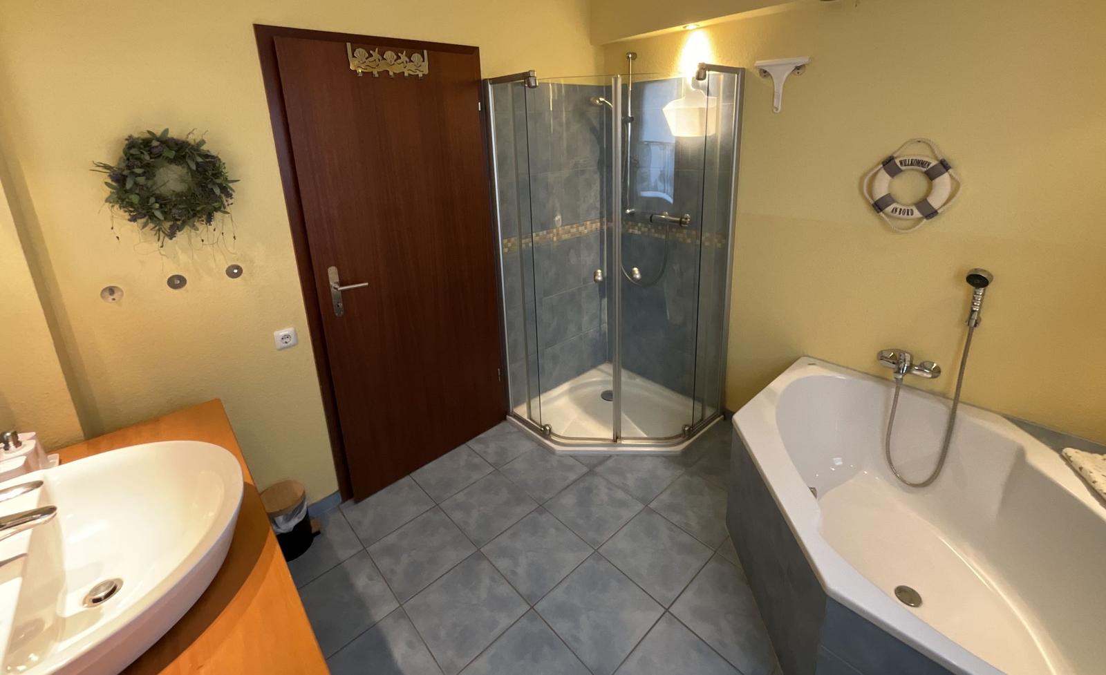 Bad mit Dusche, Badewanne und Waschbecken.