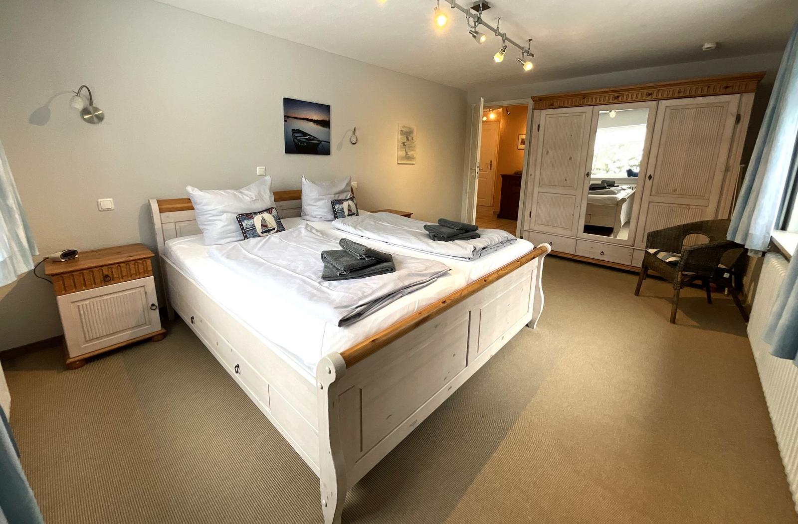 Schlafzimmer mit Doppelbett, Kleiderschrank und Nachttisch.