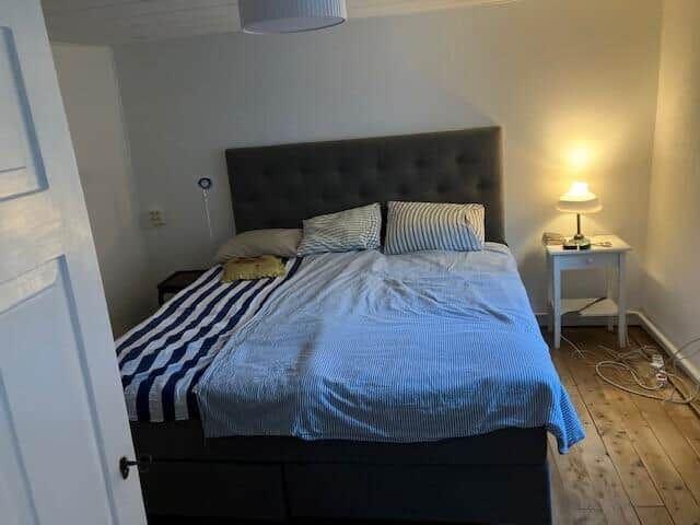 Schlafzimmer mit Bett, Nachttisch und Lampen.