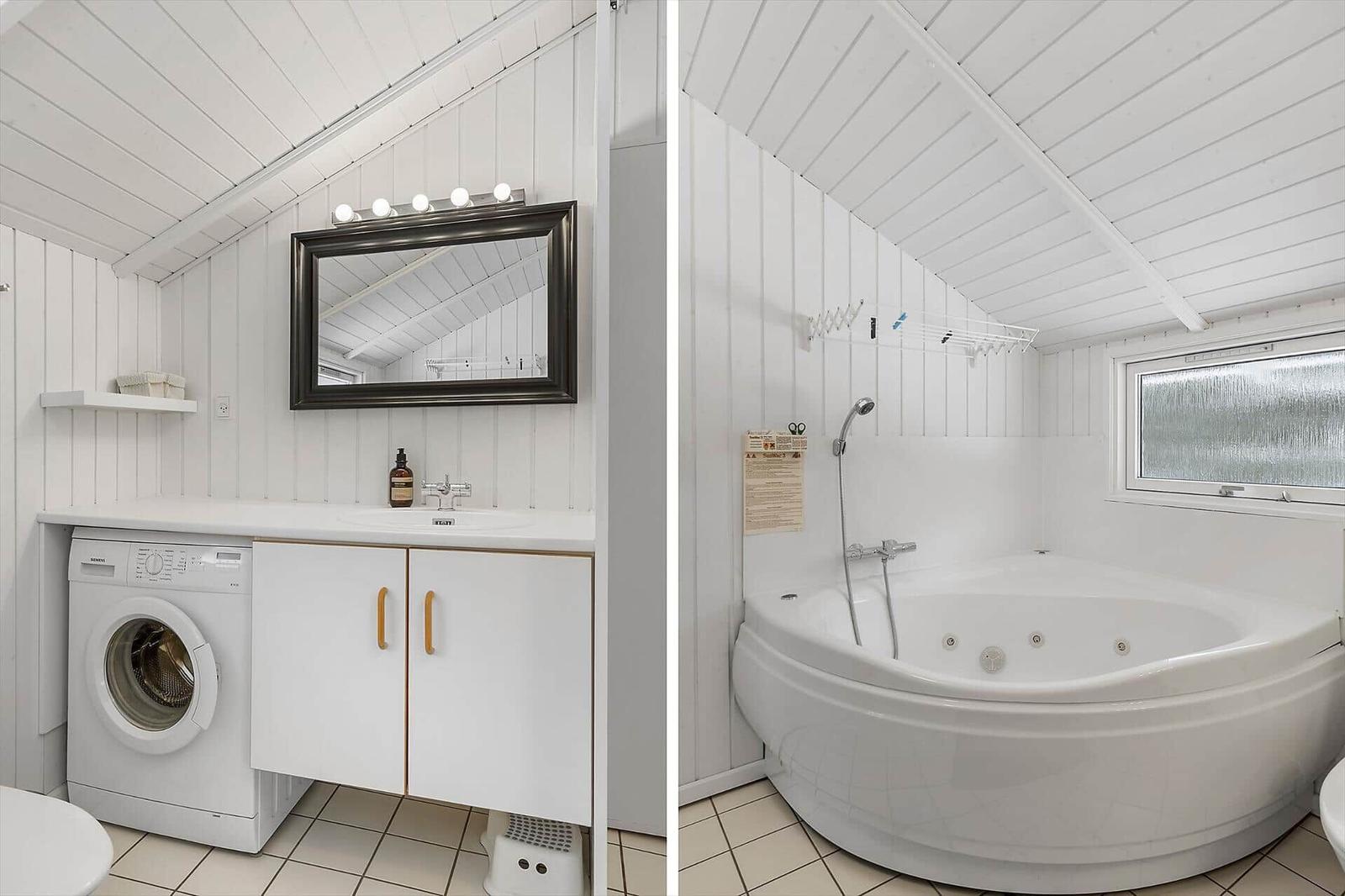 Bathroom with washing machine and bathtub under sloped ceiling