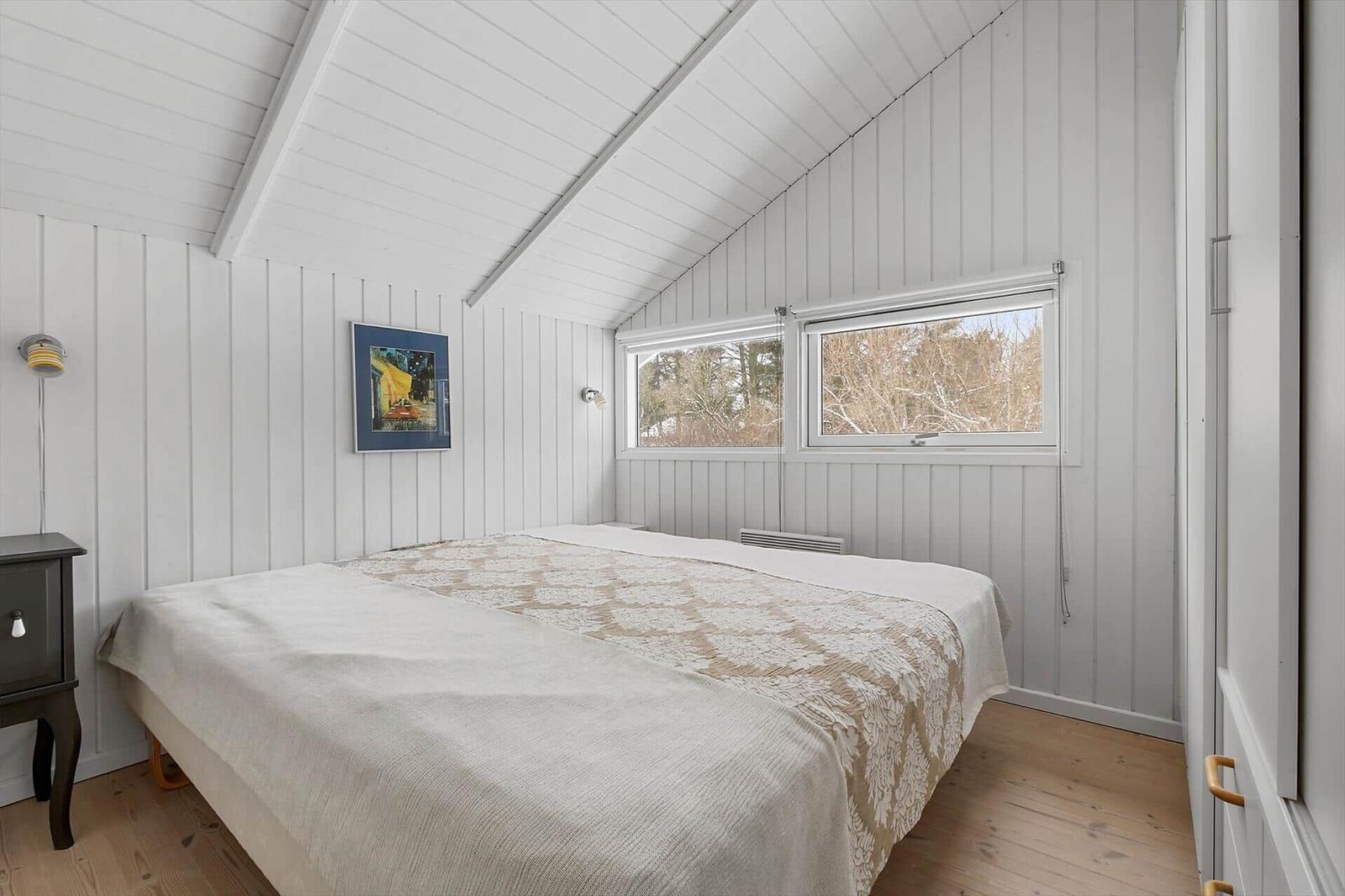 Bedroom with bed, windows and wooden floor