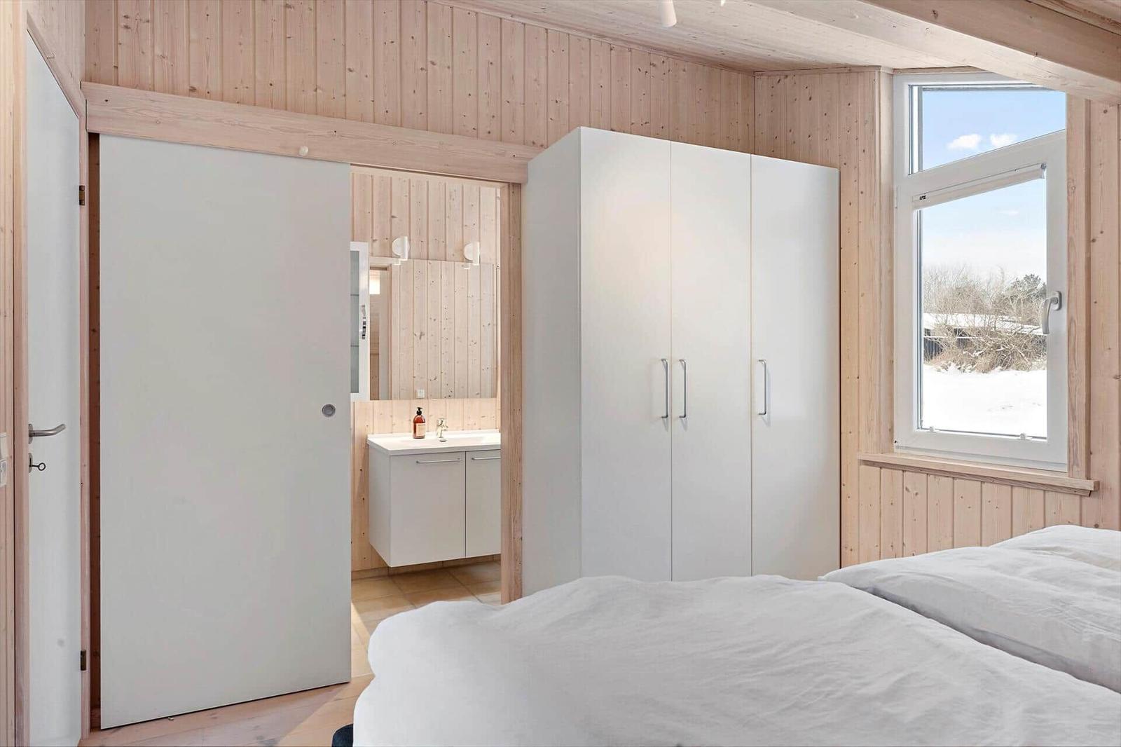 Bedroom with white closet and window view of snow.