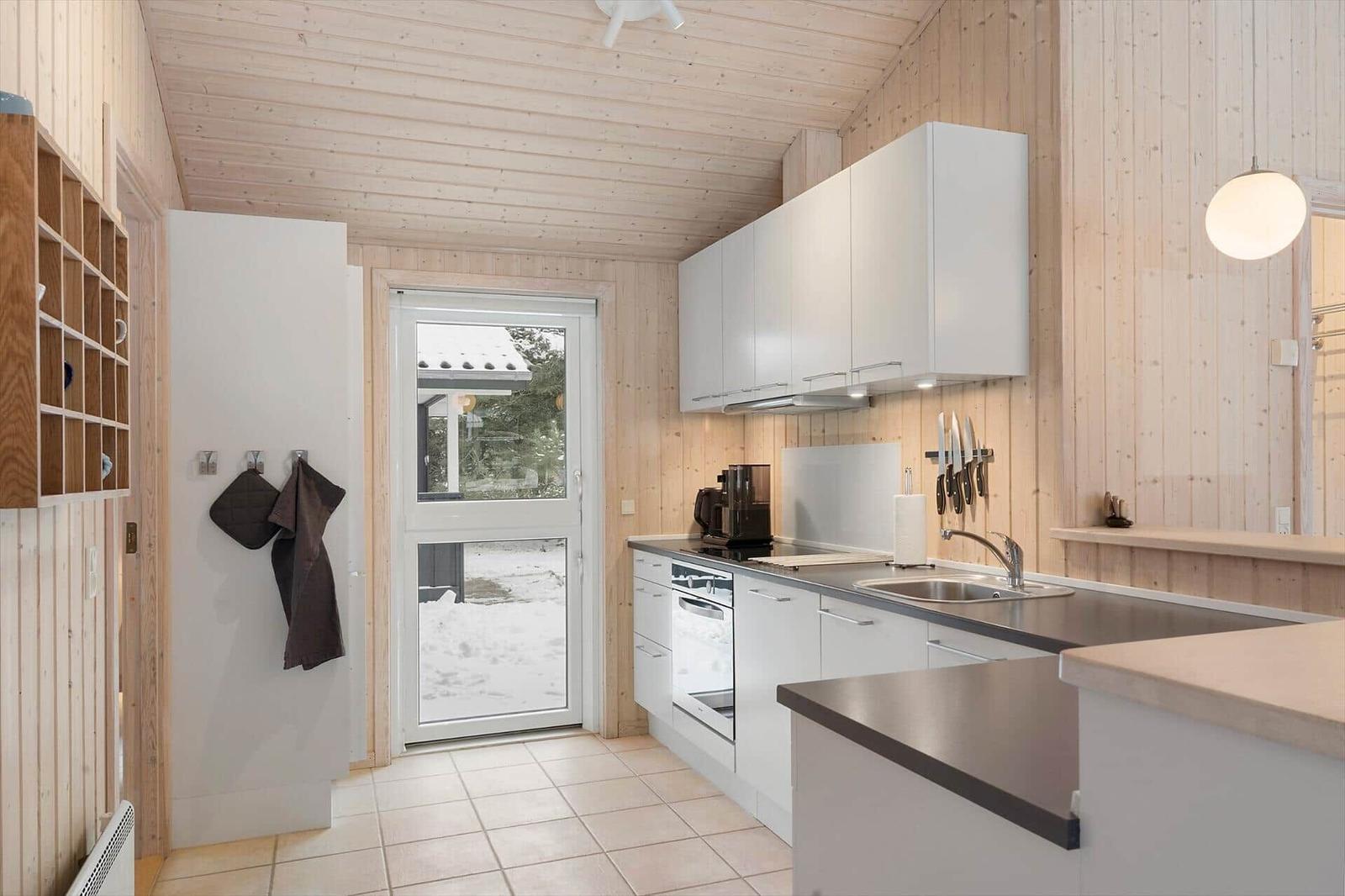 Kitchen with white cabinets, stainless steel countertop, view of snow