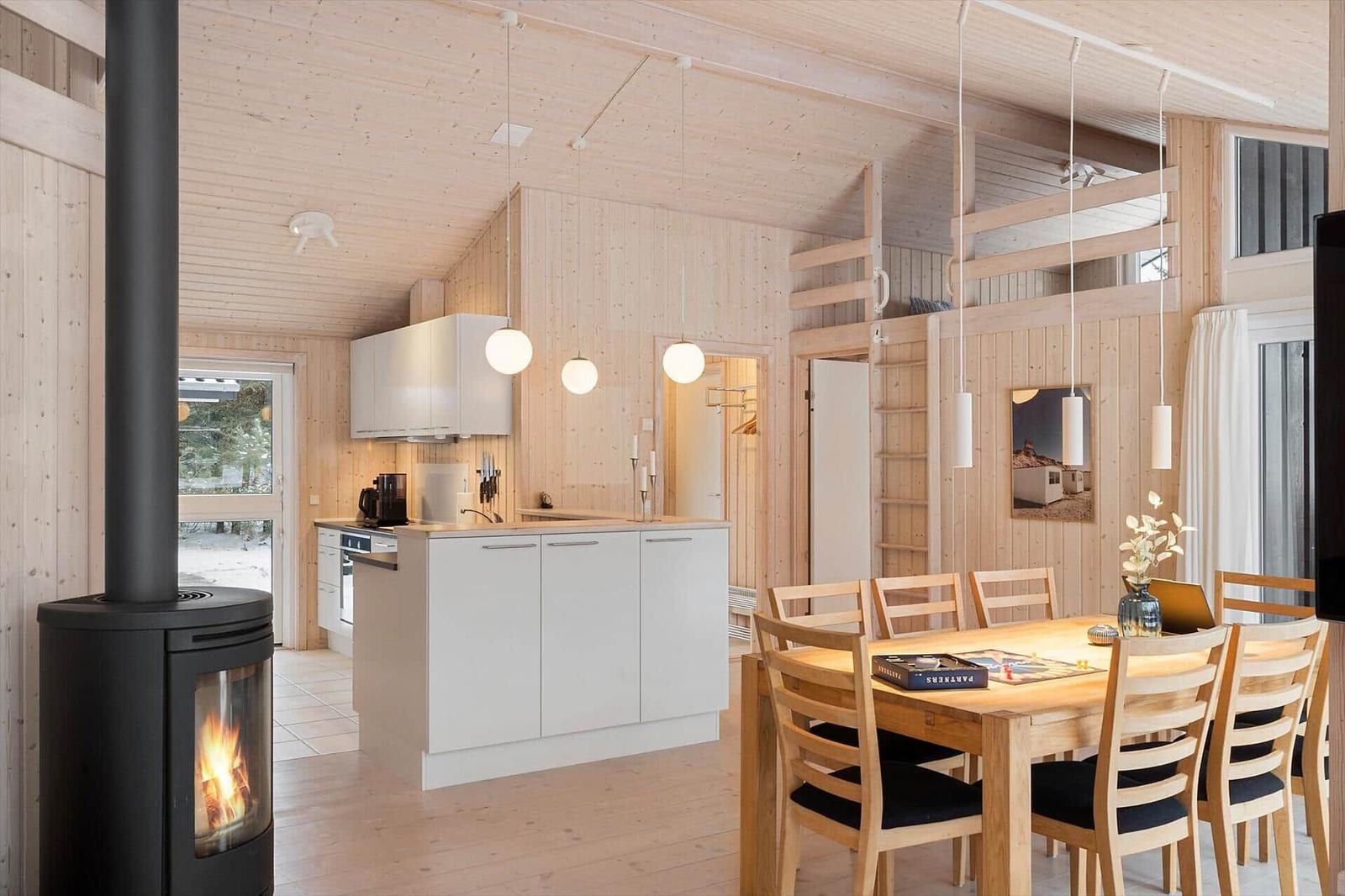Kitchen with dining table, wooden ceiling, and wood stove in house